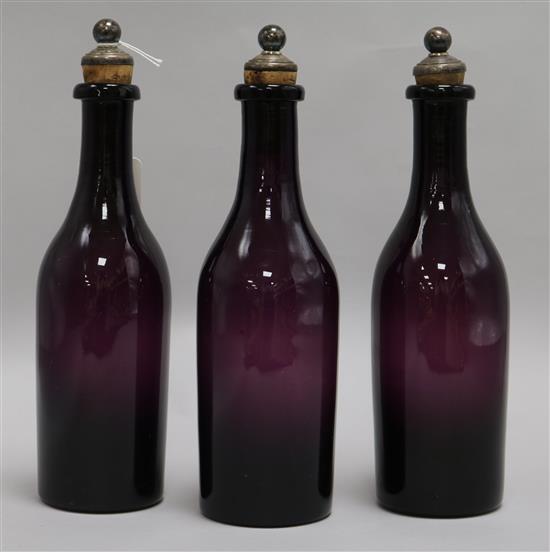 A set of three 19th century amethyst glass decanters, with plated stoppers, height 26cm